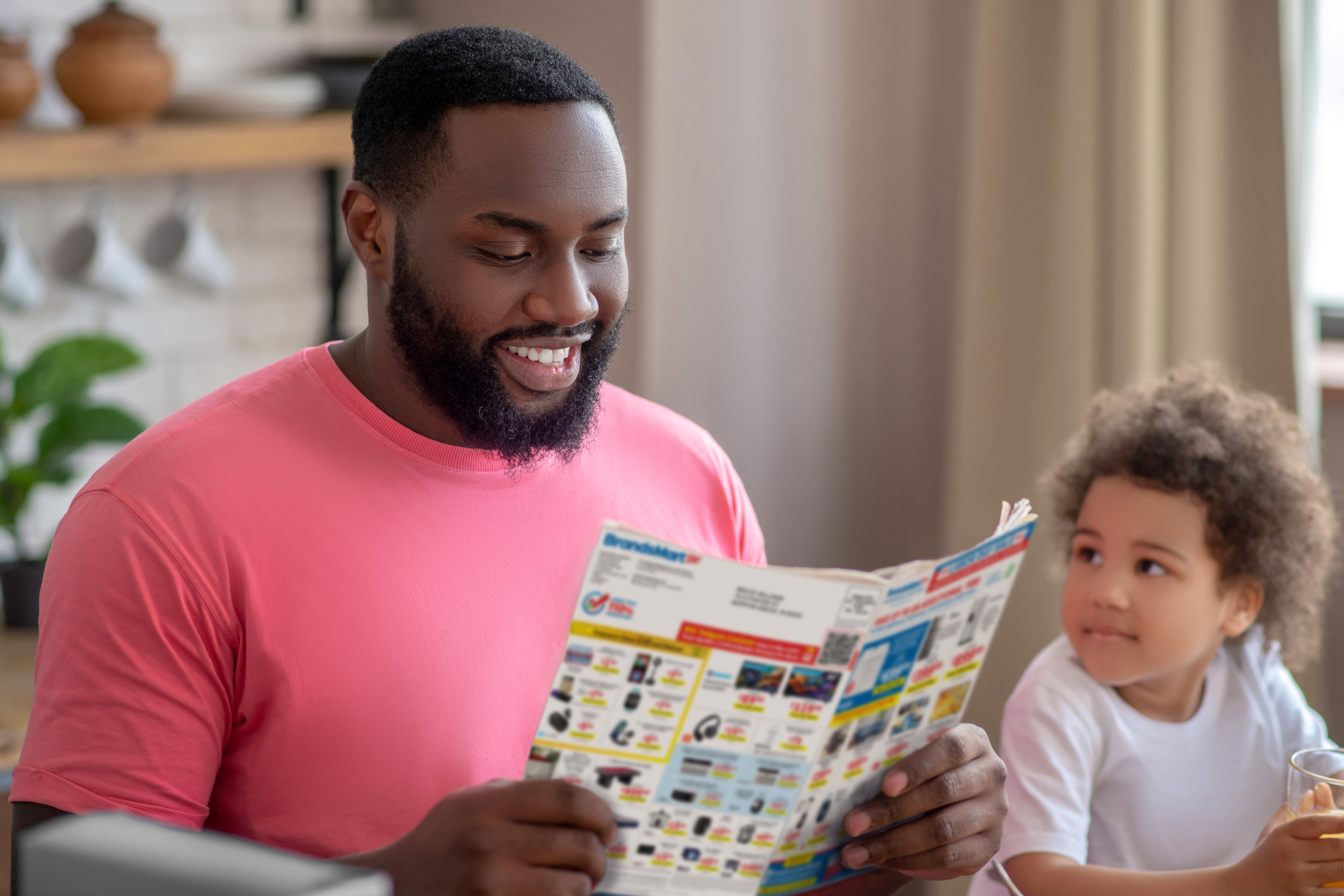 Dad Reading Paper next to Child_iStock-1227490865